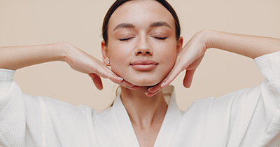 Young woman doing face building facial gymnastics self massage