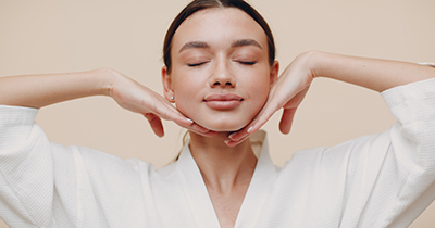 Young woman doing face building facial gymnastics self massage and rejuvenating exercises